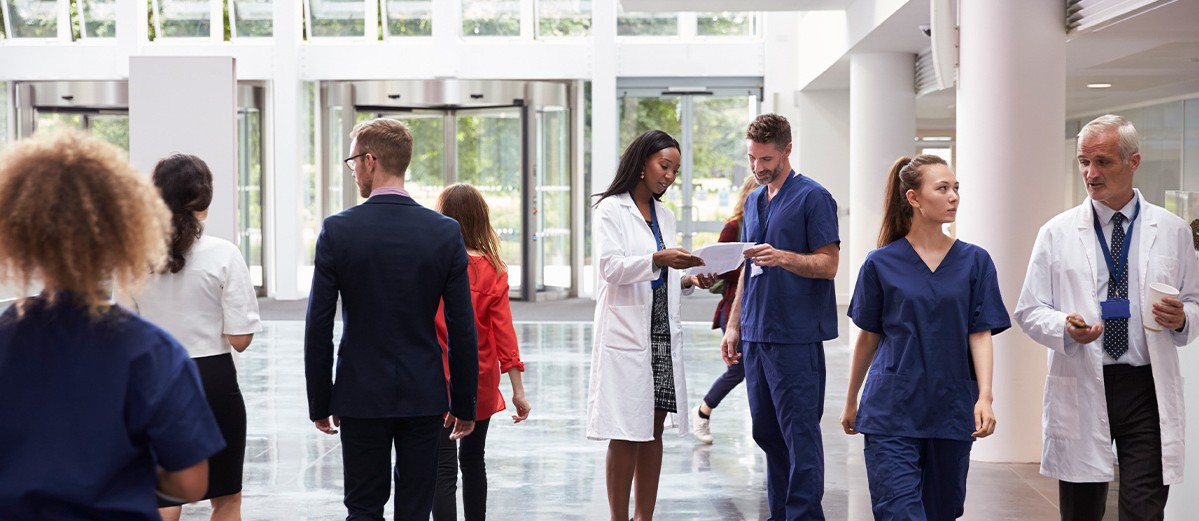 Staff In Busy Lobby Area Of Modern Hospital